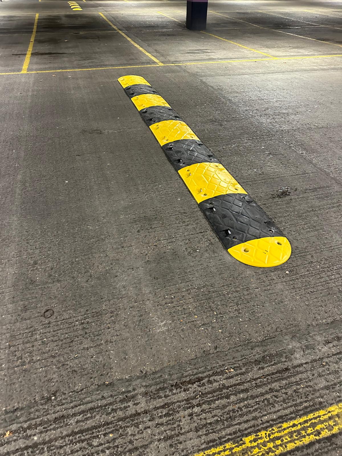 Car park traffic calming: yellow and black rubber speed bumps