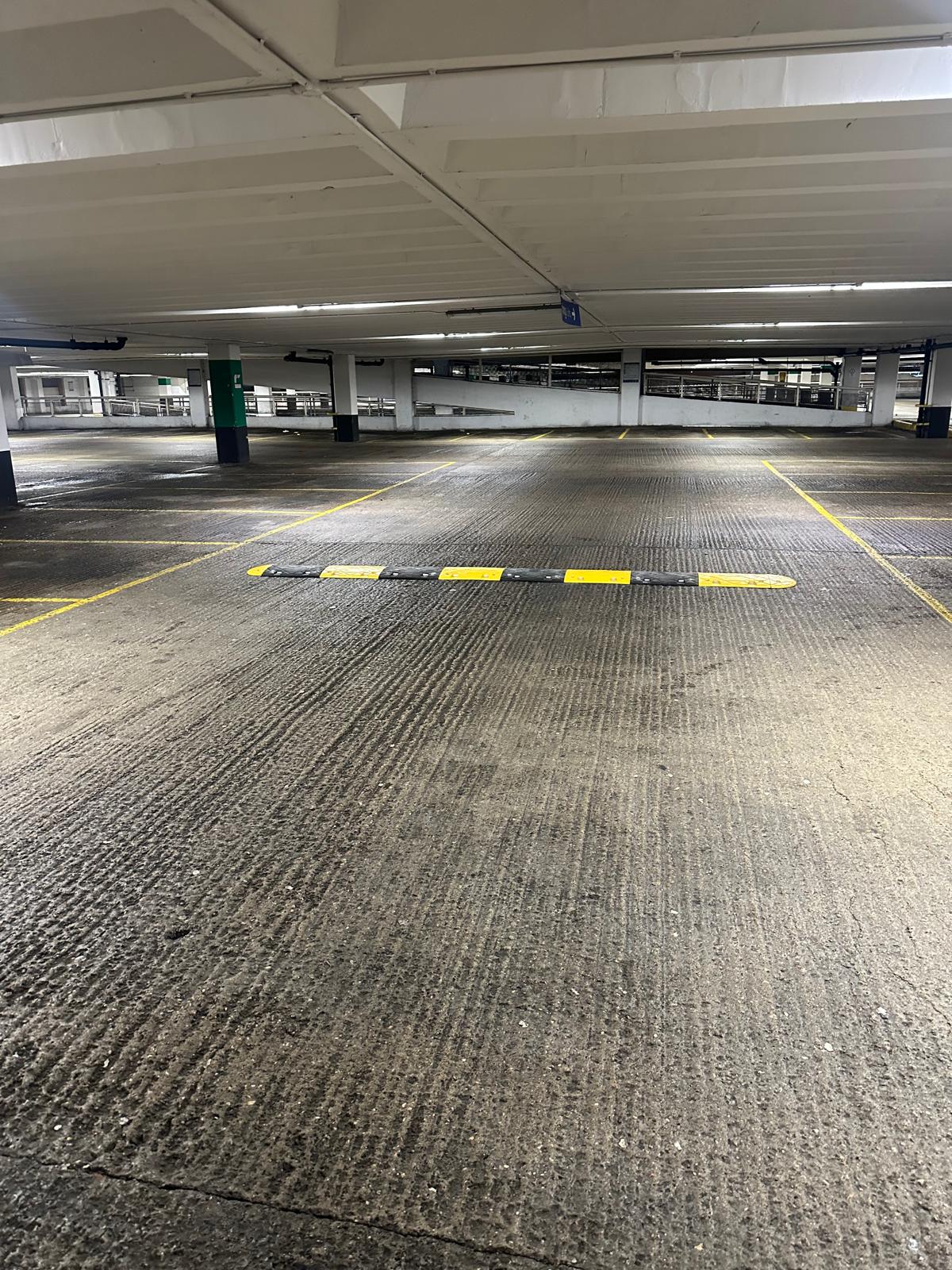 Completed yellow and black speed bump across a multi-storey car park circulation route