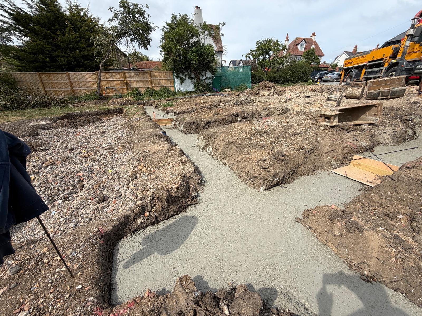 Foundation trench after excavation with setting-out markers and spoil heaps