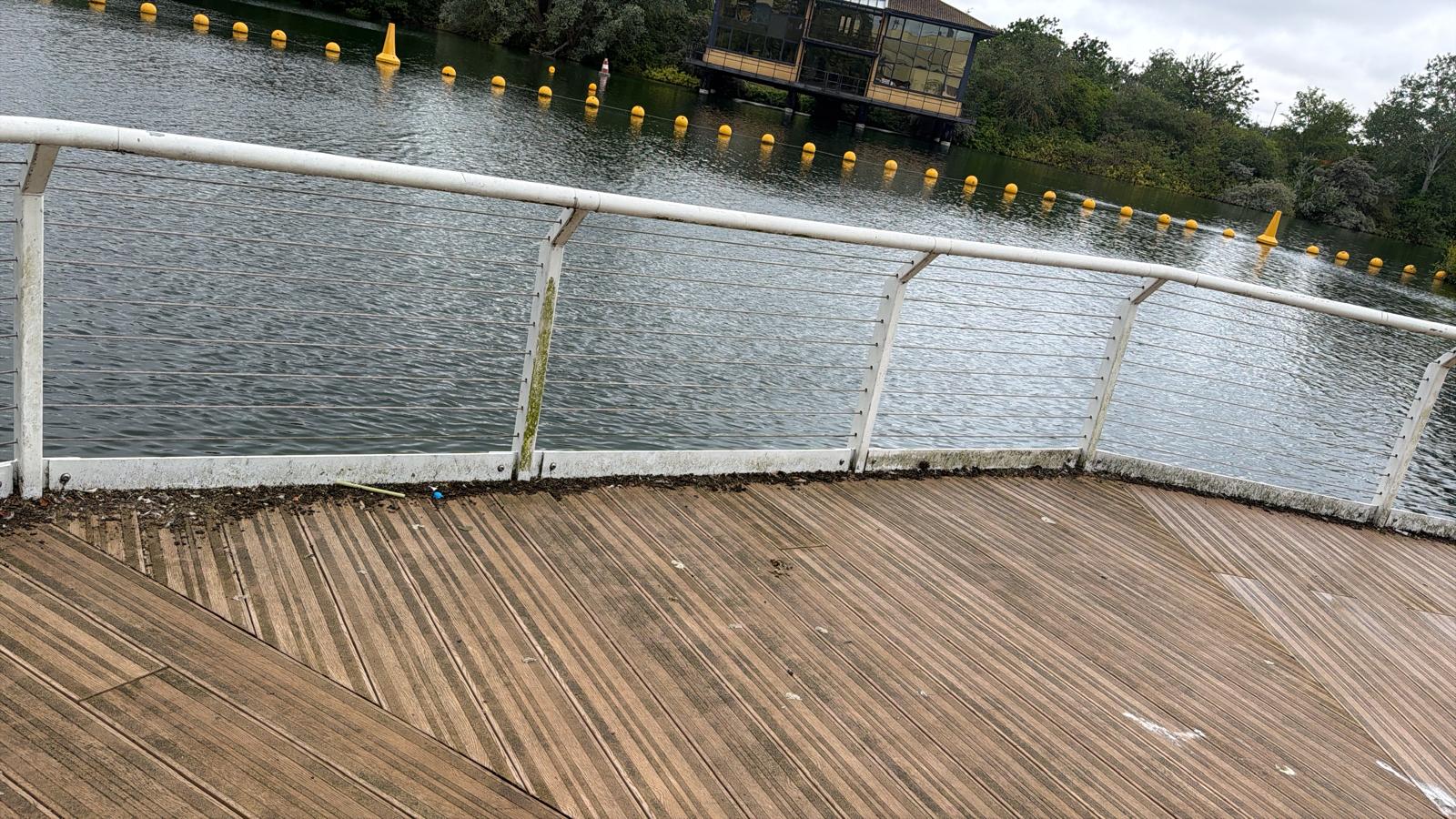 Horizontal cable railing restored along a commercial lake side timber deck