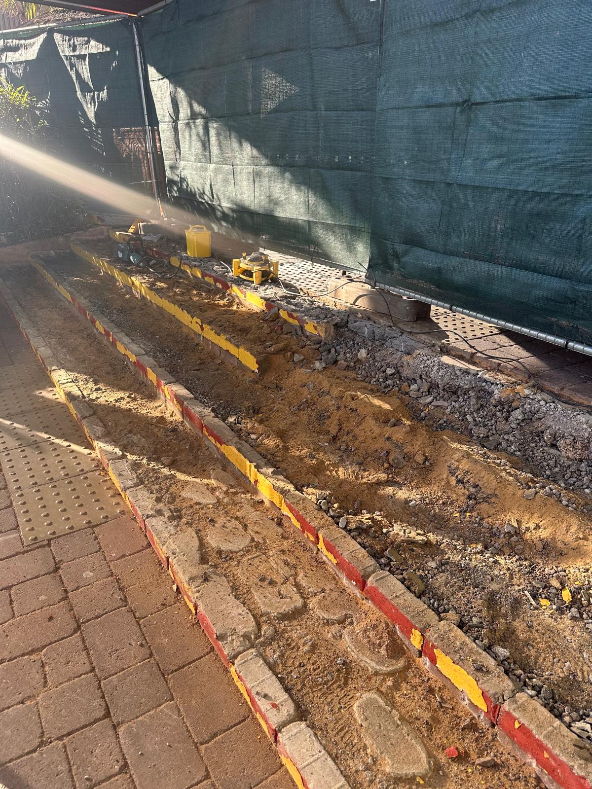 Commercial staircase during rebuild showing sand bedding, brick risers and broken-out treads