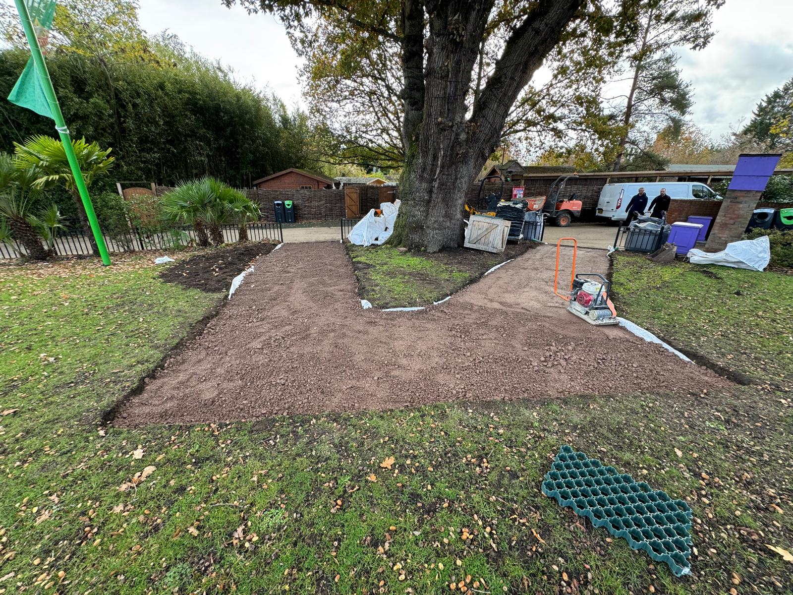 Compacted granular path bed prepared for grass reinforcement grid installation